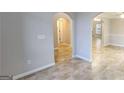 Open-concept living space features neutral paint, tile floors, and arched doorways that add architectural interest at 1230 Chris Lake Dr, Lawrenceville, GA 30046