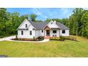 Charming two-story home with a landscaped front yard, brick stairs, and covered porch at 155 Grace Hope Dr, Brooks, GA 30205