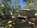 This house features a large deck and a spacious backyard bordered by lush trees, offering privacy at 261 Sally Duke Dr, Whitesburg, GA 30185