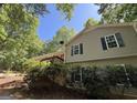 This beautiful home is surrounded by lush greenery, complemented by a cozy deck and a satellite dish at 261 Sally Duke Dr, Whitesburg, GA 30185