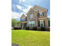 Well-manicured lawn and beautiful stone and siding accent the exterior of this stunning two-story home at 8340 Nolandwood Ln, Villa Rica, GA 30180