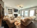 Cozy living room featuring a fireplace, built-in shelving, and comfortable reclining chairs at 8340 Nolandwood Ln, Villa Rica, GA 30180