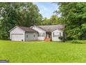Charming home with a well-manicured lawn and a welcoming front porch, set against a backdrop of mature trees at 160 Country Mill Ln, Stockbridge, GA 30281