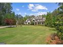 Expansive lawn with landscaping leading up to a welcoming two-story home with a charming front porch at 193 Stonegate Trl, Carrollton, GA 30116