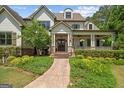 Close-up of front exterior showing the stone path, covered porch with columns, and beautiful landscaping at 193 Stonegate Trl, Carrollton, GA 30116