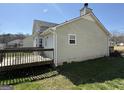 A view of the backyard deck, siding, and well-maintained lawn at 132 Scarlett Place Dr, Bowdon, GA 30108