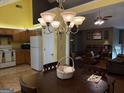 Open-concept kitchen with warm wood cabinetry, tile floors, and adjacent dining area and a view to the living room at 1432 Eagles Nest Cir, Carrollton, GA 30116