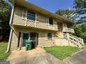 The side and front of a two-story home with wood siding, shutters, front stairs, and a green bin near the entrance at 4079 Day S Trl, Ellenwood, GA 30294