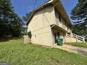 A two-story home with wood siding, shutters, and front stairs, with a lawn covered in yellow flowers on the side at 4079 Day S Trl, Ellenwood, GA 30294