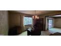 Dining room with decorative chandelier, vintage wallpaper, and adjacent sliding glass doors at 1992 Kunuga Dr, Jonesboro, GA 30236
