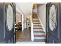 Elegant foyer with tiled flooring, featuring a staircase and views into adjacent living areas, bathed in natural light at 4031 E Meadow Dr, Duluth, GA 30096