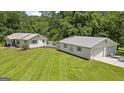 Wide shot of the home's exterior and detached garage featuring well-kept lawn and convenient rear deck at 204 First St, Bowdon, GA 30108