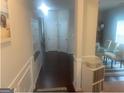 Inviting hallway with hardwood floors, decorative molding, and view into dining room at 5470 Hilltop Pass, Fairburn, GA 30213