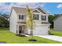 Inviting two-story home with a well-maintained lawn and attached two-car garage at 303 Limestone Circle, Conyers, GA 30013