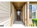 Covered front porch with a decorative front door and sidelight that is accented with siding and stone at 123 Mulberry Ct, Peachtree City, GA 30269