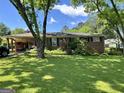 Charming brick home featuring a well-maintained lawn and covered parking at 2334 Connally Dr, East Point, GA 30344