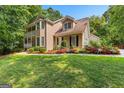 Inviting two-story home with a balcony, well-manicured lawn, and colorful flowerbeds at 210 Farr Lake Dr, Tyrone, GA 30290