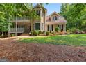 Charming two-story home with a balcony, a welcoming front entrance, and mature landscaping at 210 Farr Lake Dr, Tyrone, GA 30290