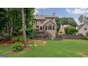 Spacious backyard with a deck, lush greenery, and a fenced-in area, perfect for entertaining at 405 Woodbrook Way, Lawrenceville, GA 30043