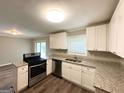 Modern kitchen featuring stainless steel appliances, granite countertops, and white cabinetry at 3948 Regent St, Douglasville, GA 30134