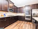 Stylish kitchen featuring granite countertops, stainless steel appliances, and dark wood cabinetry at 1243 Polk Xing, Mcdonough, GA 30252