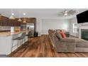 Inviting living space with a fireplace, a ceiling fan, and hardwood floors, viewed from the kitchen at 1243 Polk Xing, Mcdonough, GA 30252