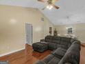 Spacious living room featuring a large sectional sofa, vaulted ceiling, ceiling fan, and hardwood floors at 552 New Hope Rd, Mcdonough, GA 30252