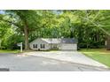 Single-story home with a large front yard, gray siding, and a driveway leading to an attached garage at 312 Iron Horse Way, Stockbridge, GA 30281