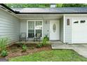 Inviting front porch with seating, decorative plants, and a decorative front door with sidelight windows at 312 Iron Horse Way, Stockbridge, GA 30281