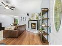 Cozy living room featuring a brick fireplace, hardwood floors, and a comfortable leather sofa at 312 Iron Horse Way, Stockbridge, GA 30281