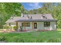 Beautifully renovated home with a modern farmhouse design, featuring a cozy front porch and landscaped yard at 1572 Hines Rd, Moreland, GA 30259