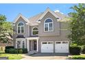 Charming two-story home featuring an attached two-car garage and well-manicured front lawn at 4527 Village Springs Run, Dunwoody, GA 30338