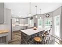 Modern kitchen with gray cabinets, stainless steel appliances, and a center island with bar stool seating at 4527 Village Springs Run, Dunwoody, GA 30338