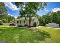 Charming home with manicured lawn, detached garage and tasteful landscaping on a desirable lot at 1130 Rawlings Dr, Rutledge, GA 30663