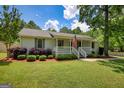 Charming home features a well-manicured lawn, an inviting porch, and delightful landscaping for great curb appeal at 1130 Rawlings Dr, Rutledge, GA 30663