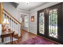 Welcoming foyer with hardwood floors, staircase, black front door, and elegant decorative details at 1850 Linnet Ne Ct, Roswell, GA 30075