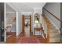 Inviting foyer featuring hardwood floors, staircase, and a view into a living room through wooden french doors at 1850 Linnet Ne Ct, Roswell, GA 30075