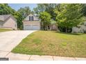 Well-manicured front lawn leads to a charming home with a convenient two-car garage at 832 Windy Mill Ct, Temple, GA 30179