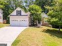 Charming home featuring a two-car garage, stone accents, and well-maintained front yard at 832 Windy Mill Ct, Temple, GA 30179
