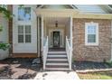 Inviting covered front porch with stone facade and classic white railing details at 832 Windy Mill Ct, Temple, GA 30179