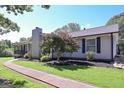 Home showcasing lovely landscaping, complemented by a paved walkway and a classic stone chimney at 8321 Banks Mill Rd, Douglasville, GA 30135