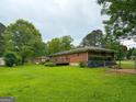 Spacious backyard featuring a deck, lush lawn, mature trees, and a chain-link fence at 5141 Hiram Lithia Springs Rd, Powder Springs, GA 30127