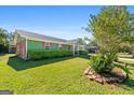Landscaped lawn and a green exterior of this home featuring colorful shutters at 120 Greenview Ter, Mcdonough, GA 30253