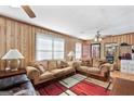 Cozy living room featuring wood paneling, plush sofas, and area rug at 120 Greenview Ter, Mcdonough, GA 30253