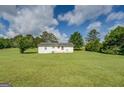 Large back yard with trees and green grass is perfect for or pets to play at 2809 South Ola Rd, Locust Grove, GA 30248