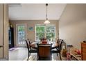 Bright dining area featuring a dark wood table, black chairs, and a view to the backyard through a large window at 8915 Tweeddale Dr, Winston, GA 30187