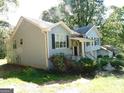 Side view of a two-story home showing the landscape, siding, and an outbuilding at 1306 Stonemont Rd, Auburn, GA 30011