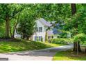 Beautiful home surrounded by mature trees and lush greenery, featuring a well-manicured lawn and driveway at 97 Coral Dr, Whitesburg, GA 30185