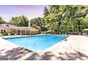 Large community pool surrounded by lounge chairs and mature trees, perfect for relaxation and recreation at 2119 Pine Heights Ne Dr, Atlanta, GA 30324
