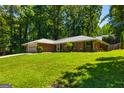 Traditional brick ranch home with mature trees, a two-car garage and a well-kept lawn at 105 Lake Forest Dr, Peachtree City, GA 30269
